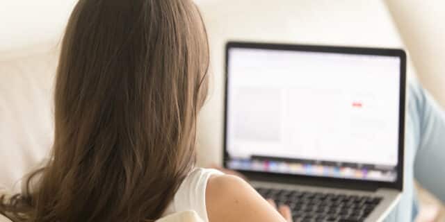 Woman creating subtitles on comfortable sofa at home