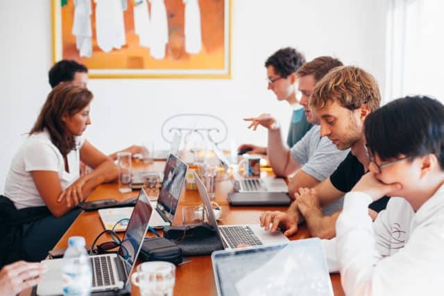 Gruppe von Mitarbeitern arbeiten konzentriert am Tisch