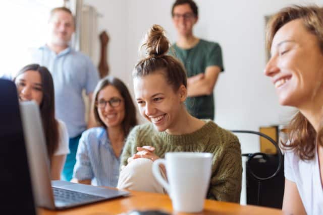 Menschen in einem Meeting vor einem Laptop