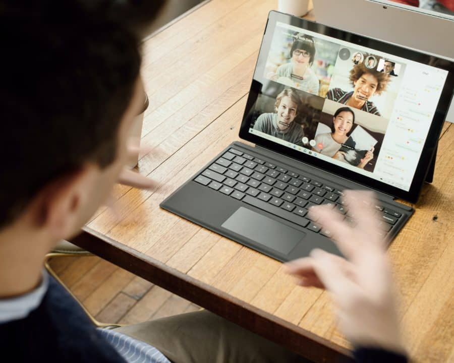 Students attending to an online zoom meeting displayed on a Microsoft Surface device