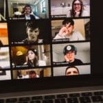 Student faces during a remote meeting displayed on laptop screen