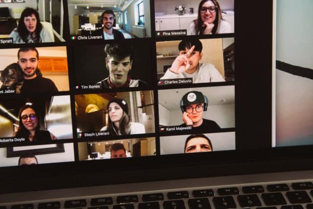 Student faces during a remote meeting displayed on laptop screen