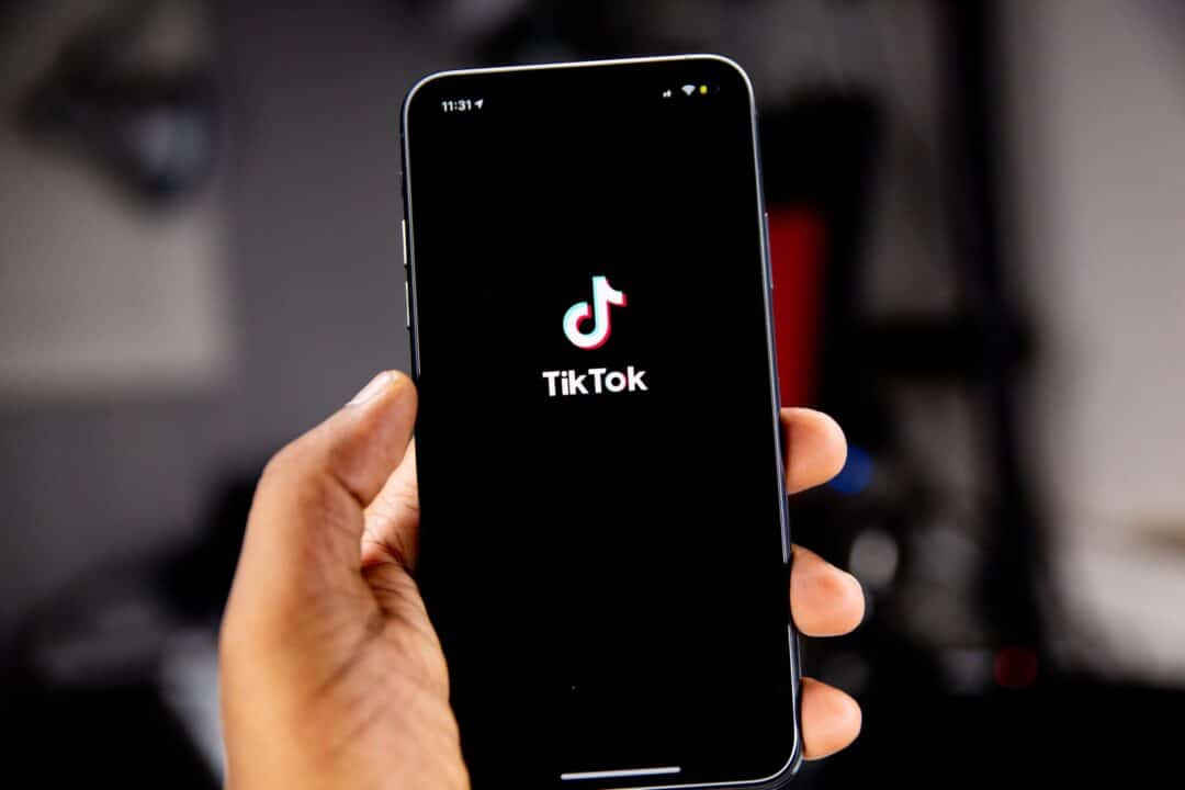 person holding black iphone 5 with the TikTok app open