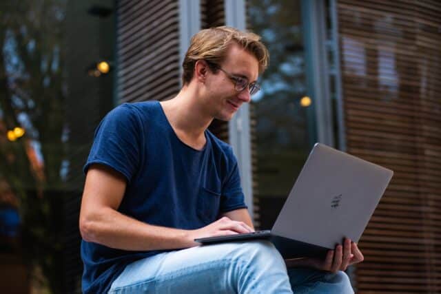 Mann lächelnd vor seinem Laptop