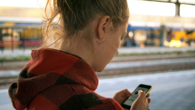 A woman holding phone at the train station