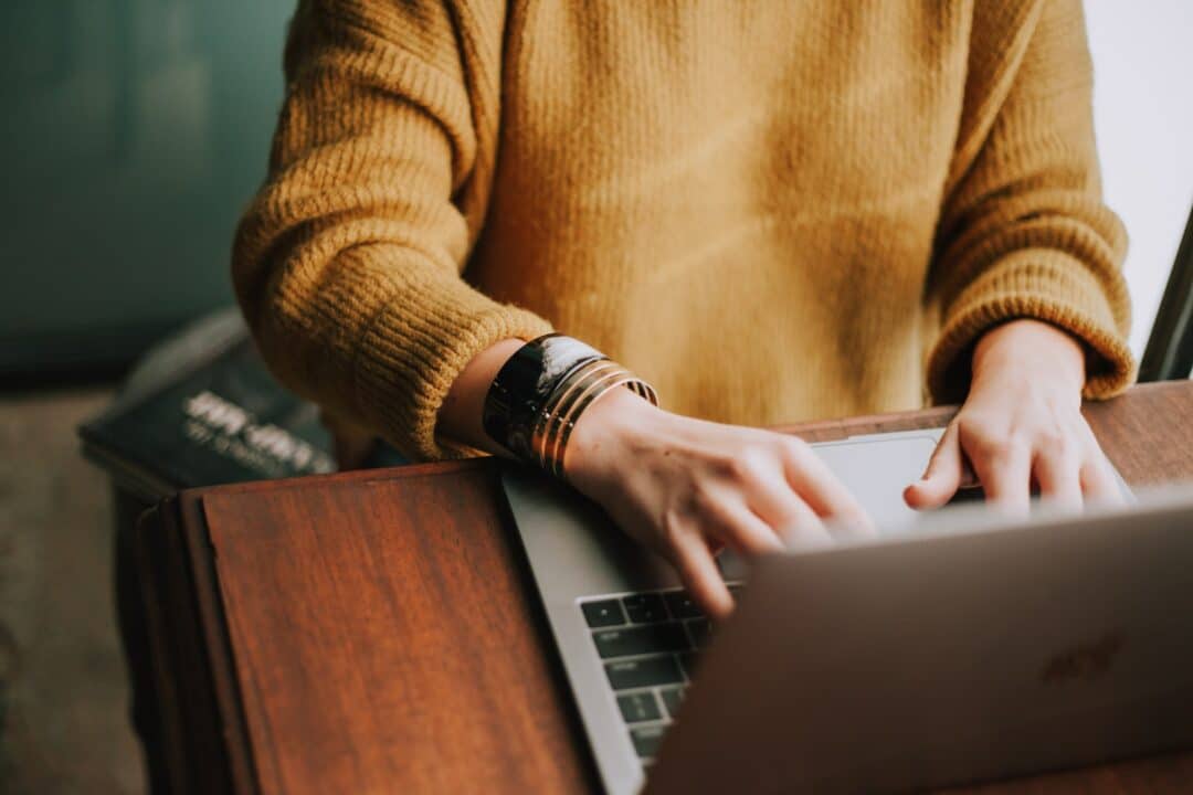 Persoon die een laptop gebruikt om spraak naar tekst om te zetten.