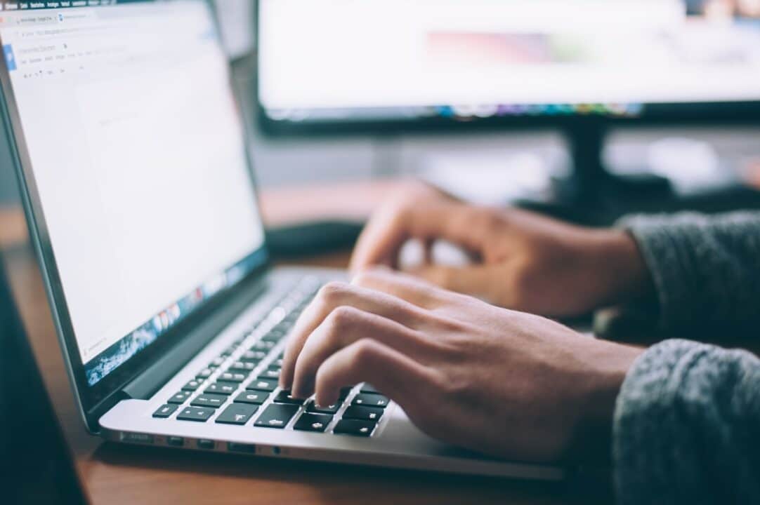 Person transkribiert selbstständig am Mac Book Pro