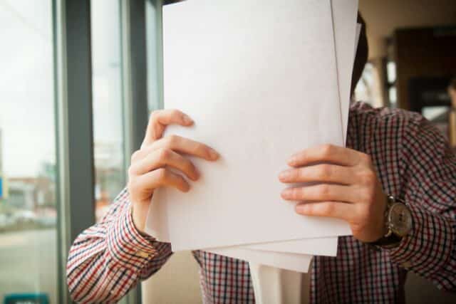 person holding white paper to type out interview